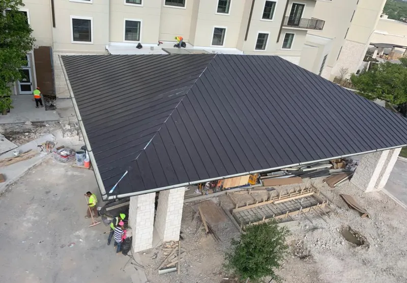Metal roofing installation team working on a commercial building in Natchitoches